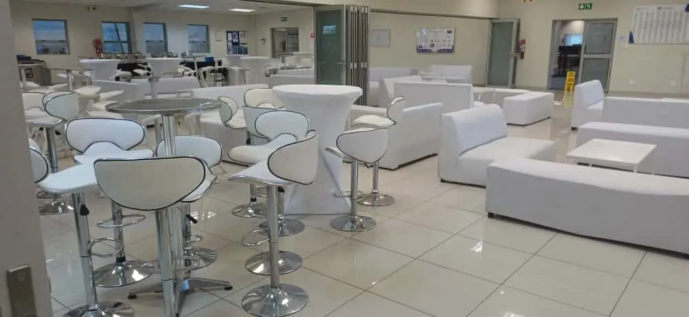 Cocktail tables and bar stools paired with white lounge couches in a corporate venue — full cocktail and bar setup hire in Johannesburg and Pretoria