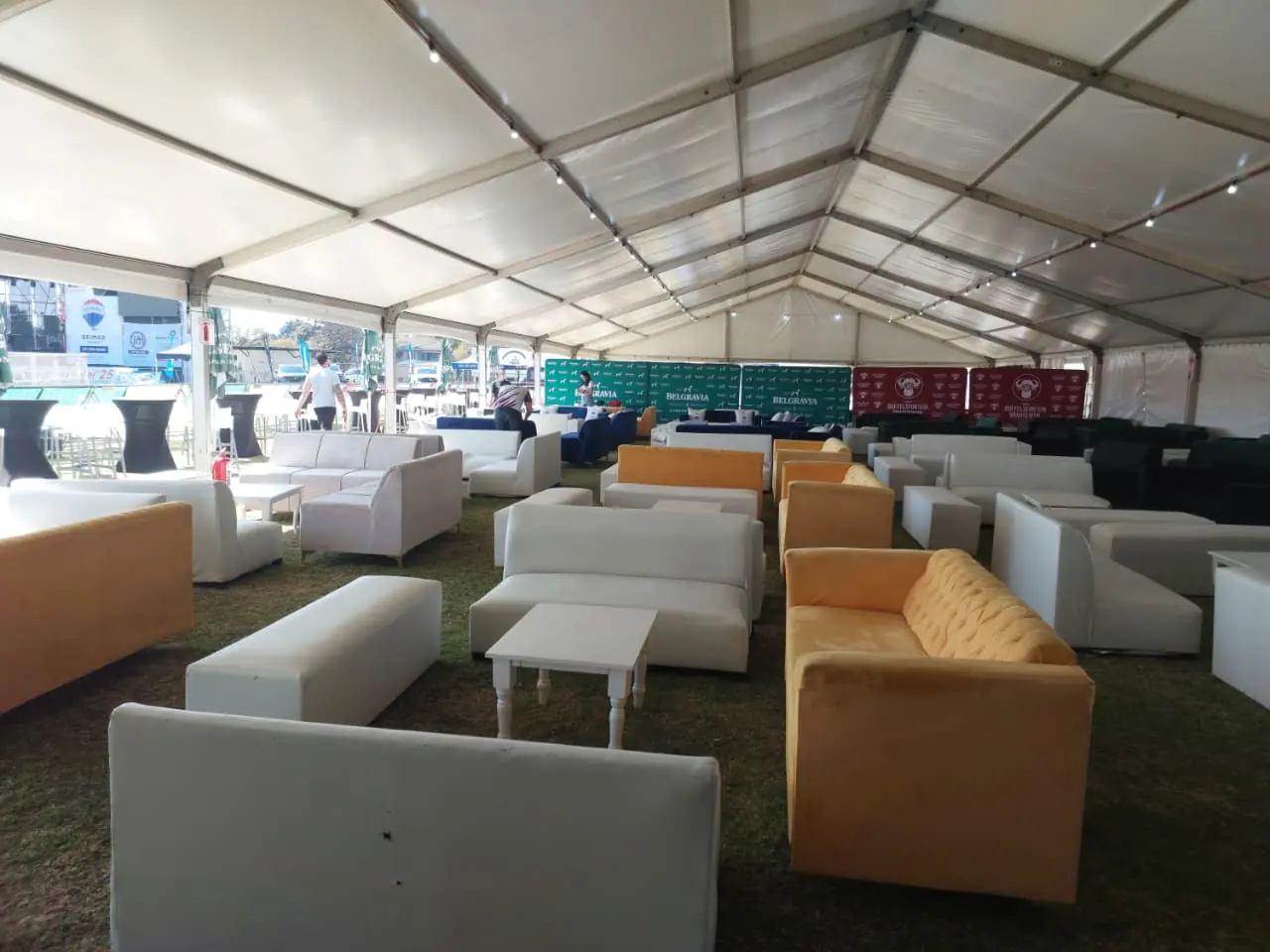 Lounge sofas and coffee tables arranged inside a large marquee