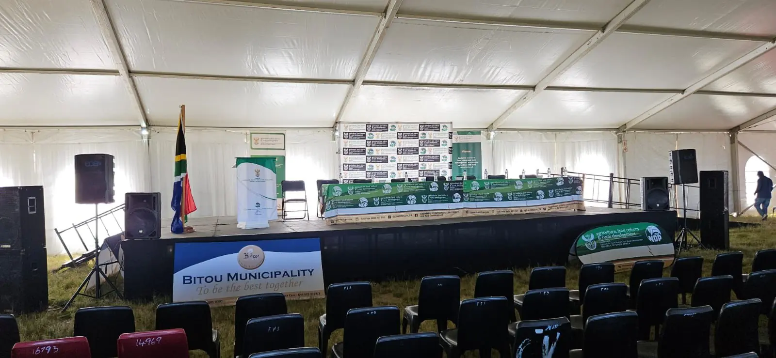 Conference stage and chairs set up inside a white marquee