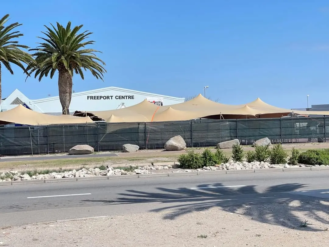 Sand-coloured stretch tents covering a paved outdoor venue