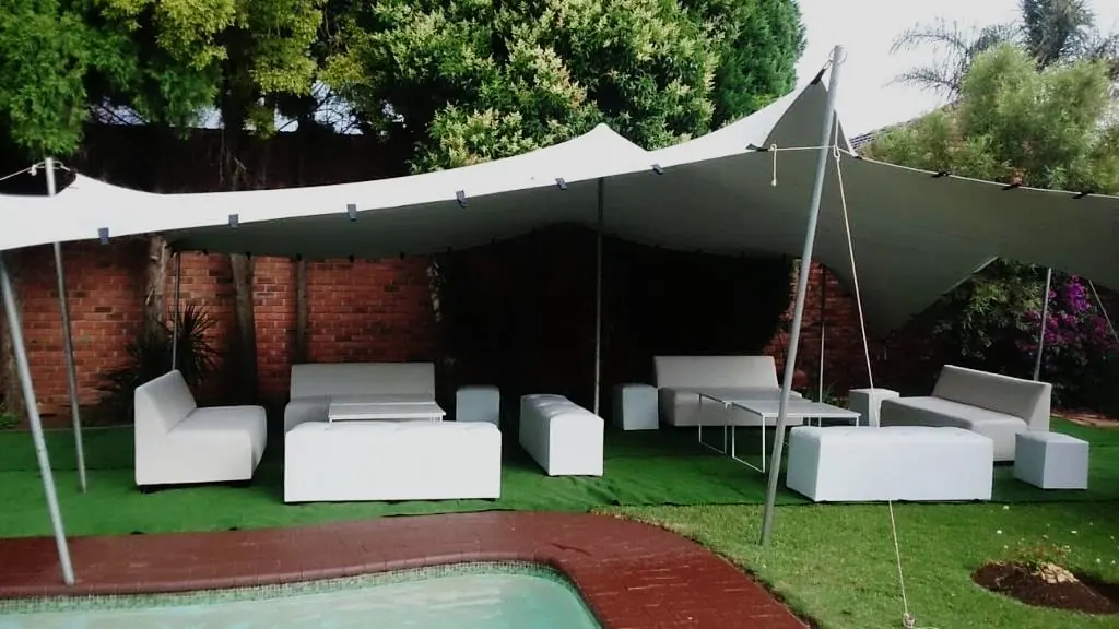 Ivory stretch tent over white lounge furniture in a garden