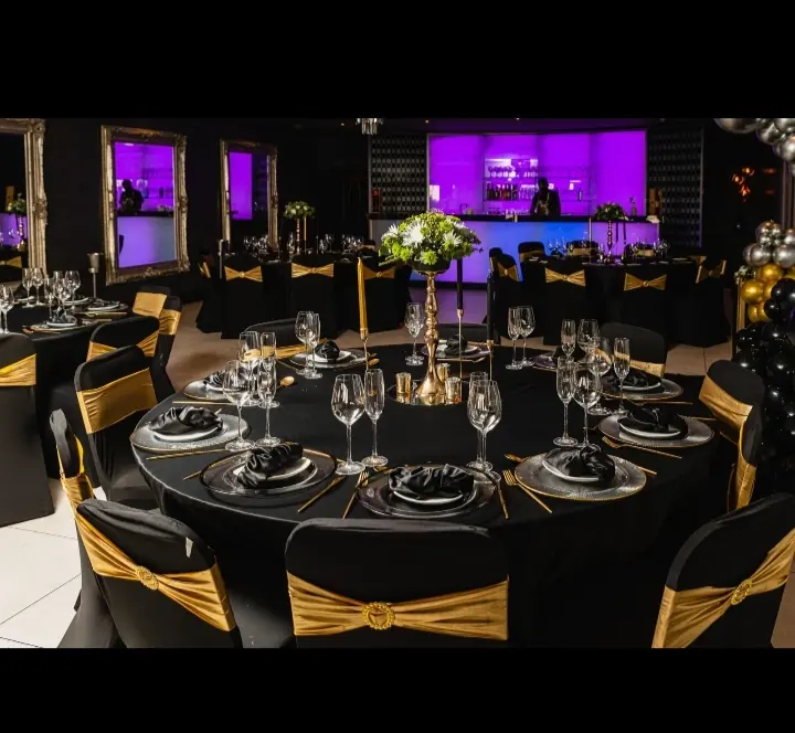 Round banquet tables and chairs inside an event marquee with stage lighting