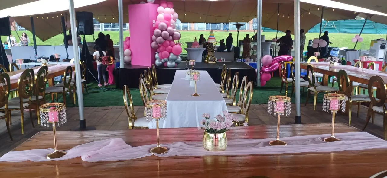 Decorated outdoor dining tables with white chairs and pink flowers