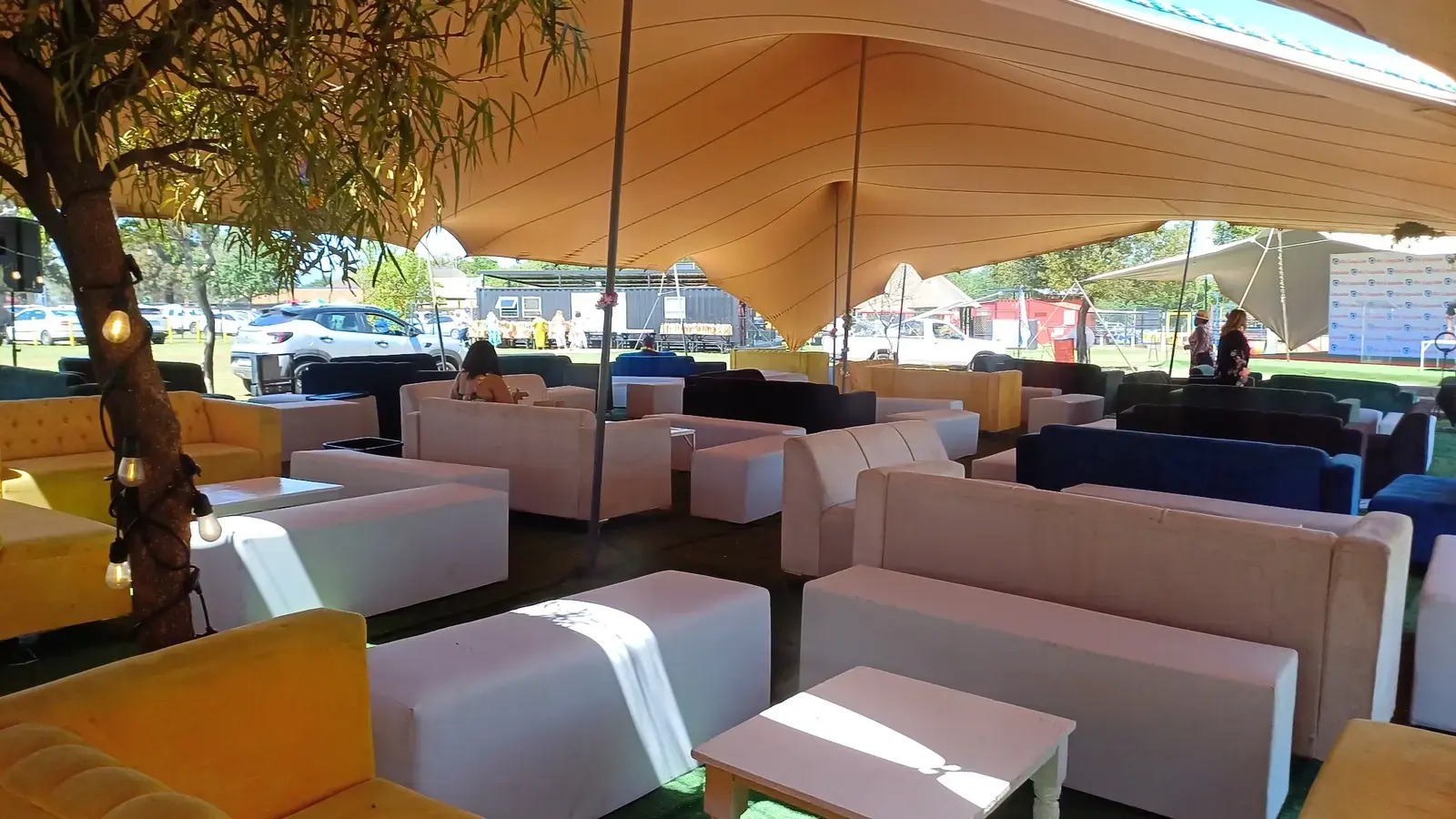 White and colourful lounge furniture hire arranged under a stretch tent in Johannesburg