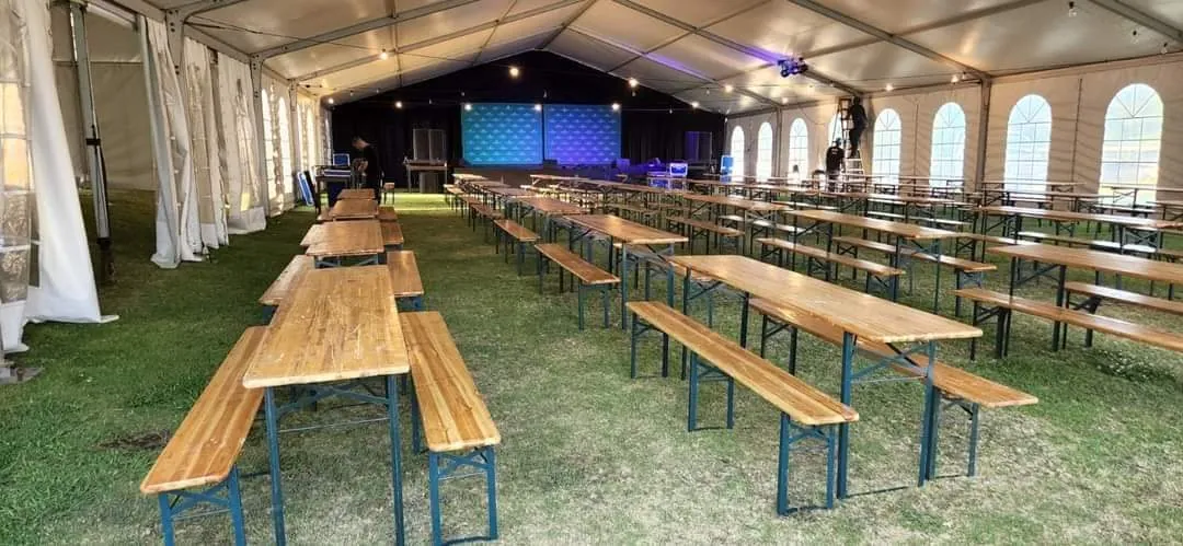 Beer bench sets at large outdoor festival with stretch tent and umbrellas — beer bench hire Gauteng South Africa