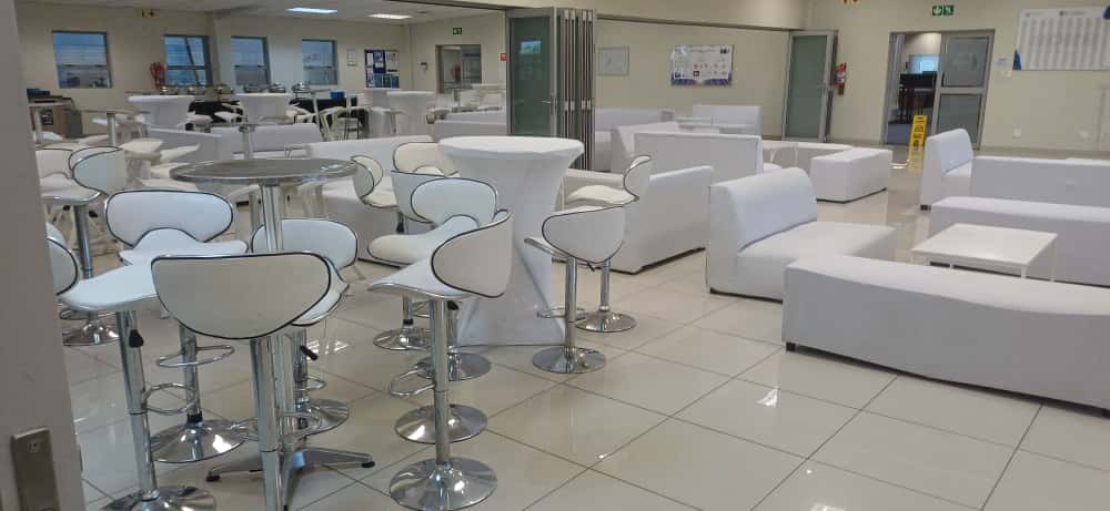 Cocktail tables and bar stools paired with white lounge couches in a corporate venue — full cocktail and bar setup hire in Johannesburg and Pretoria