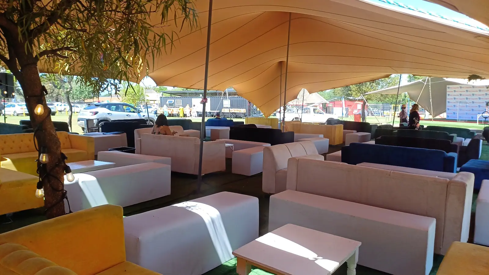 White and colourful lounge furniture hire arranged under a stretch tent in Johannesburg